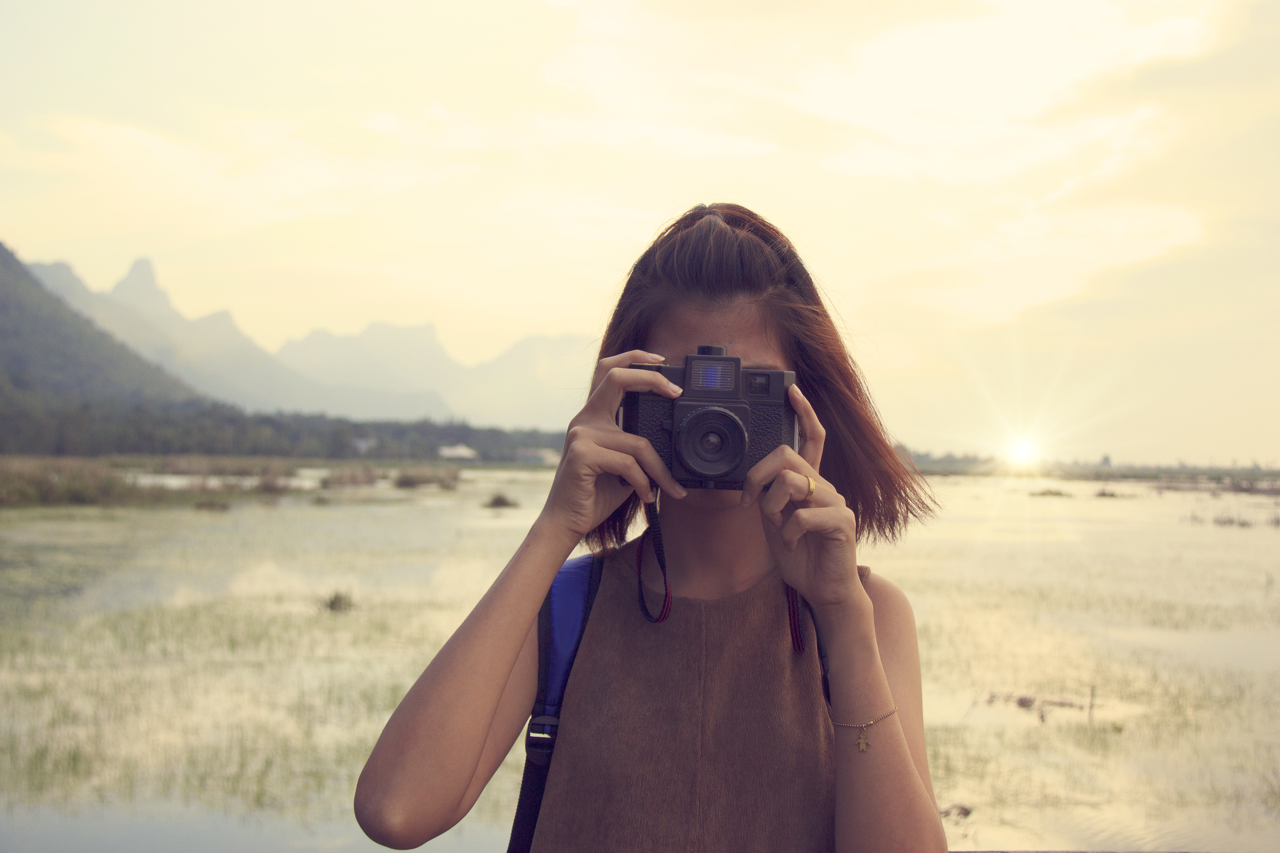 Hipster Traveler with backpack and taking photo of amazing lands